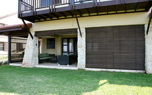 Wooden roller blinds around outdoor patio